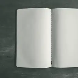 Koyu, benekli gri bir zemin üzerinde yukarıdan çekilmiş, iki sayfası da bomboş duran açık bir defter.